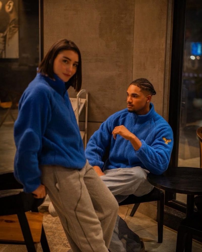 FUE Alpine Polar Fleece - two models wearing blue polar fleece sweaters in casual indoor setting