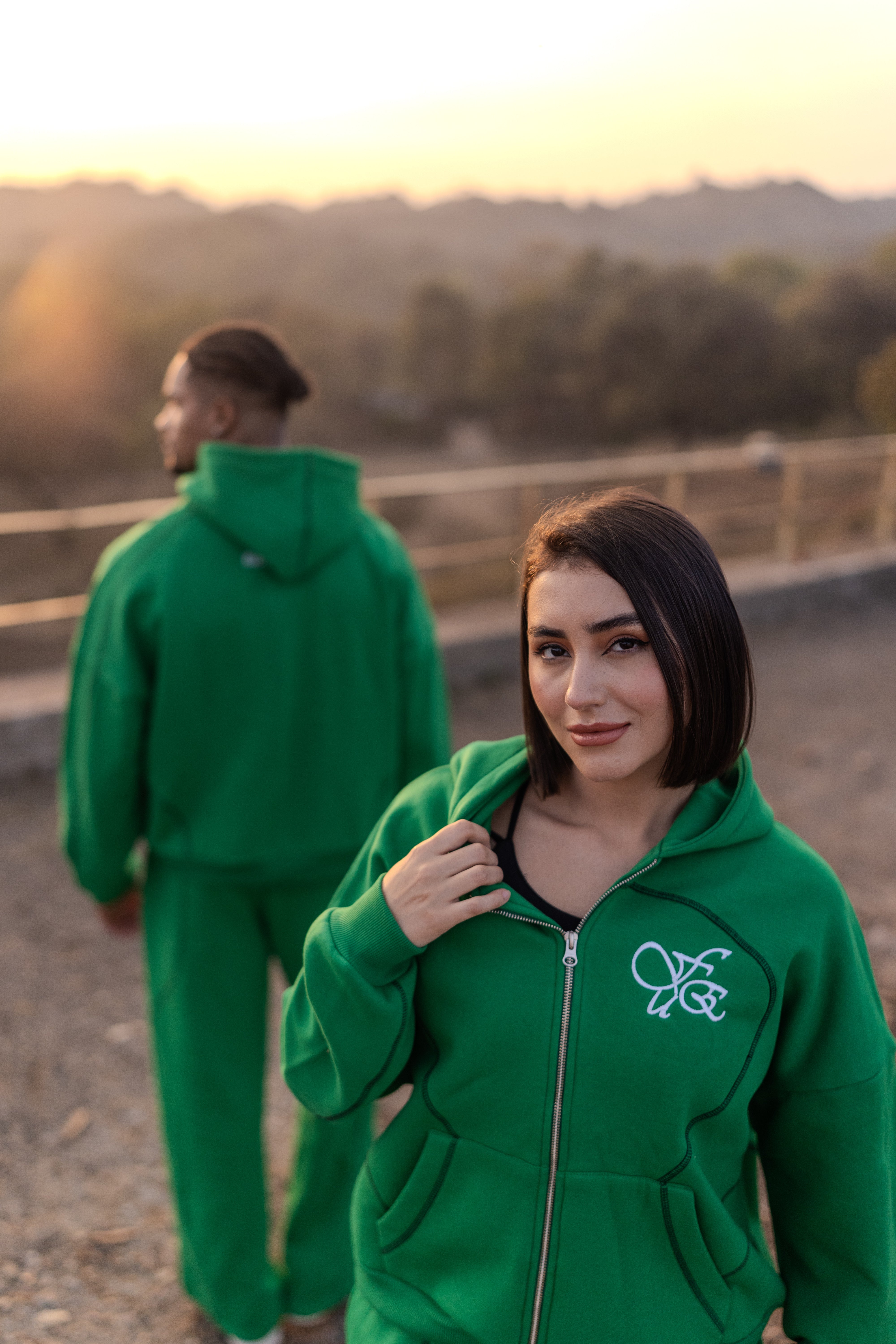 FUE Everyday Essential Sweatpants Green - two models wearing green tracksuits outdoors with scenic background