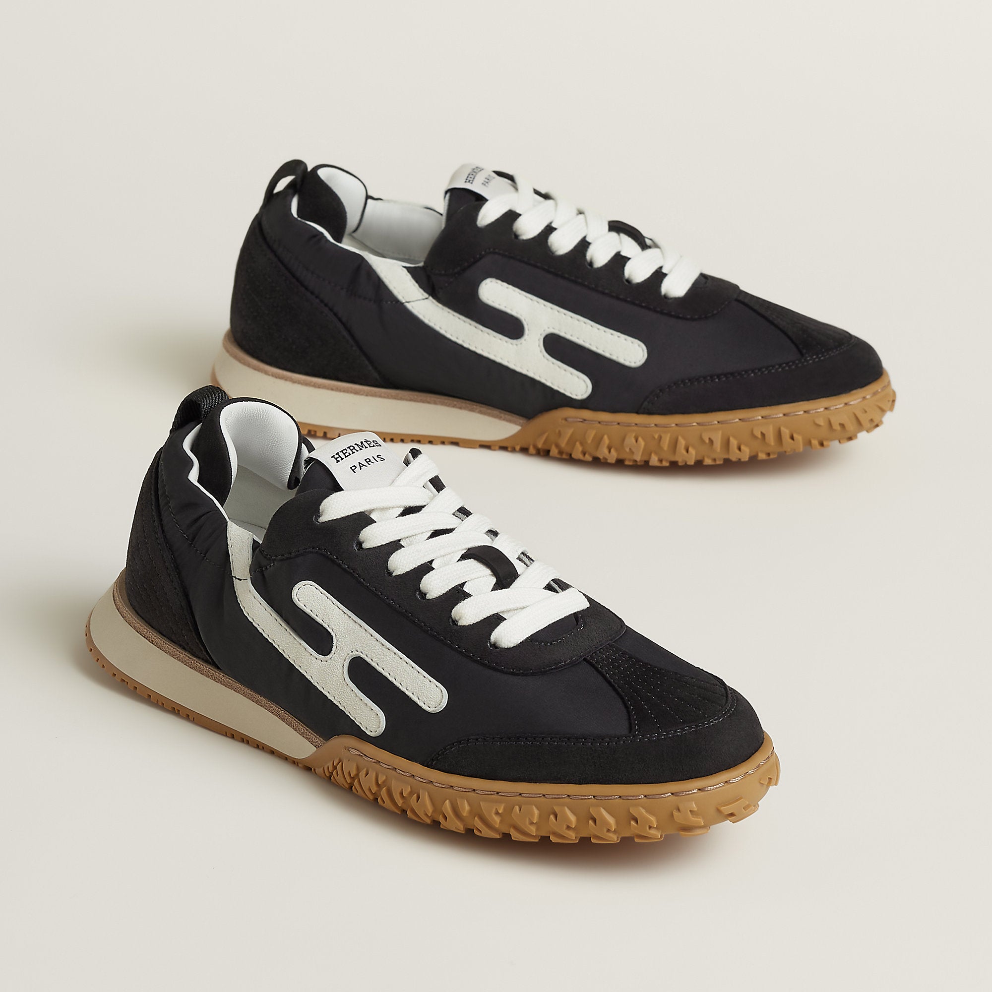 Hermes Jet Sneaker in Noir Blanc, side profile showing the signature H detail