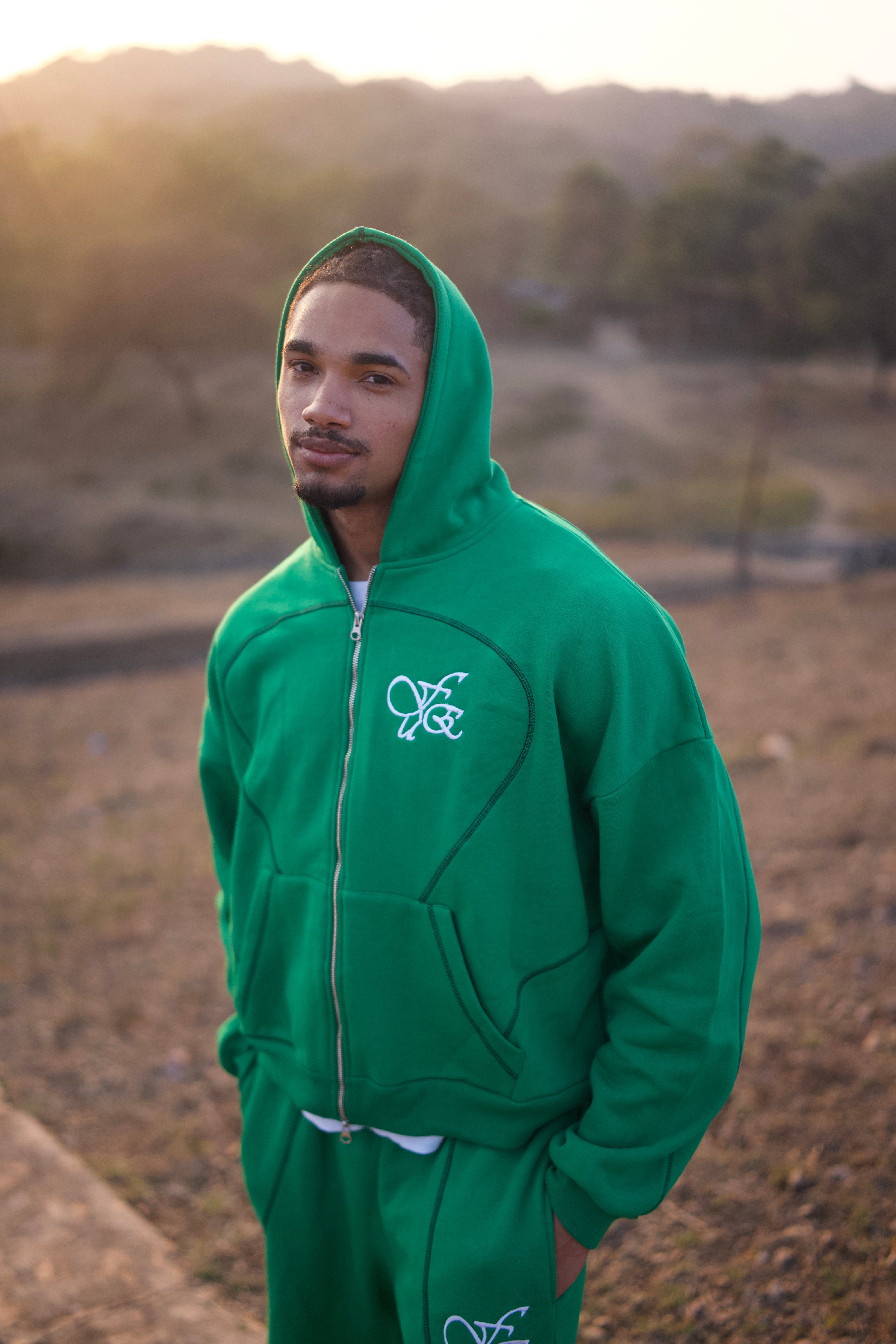 FUE Everyday Essential Sweatpants Green - male model wearing green hoodie with FUE logo outdoors
