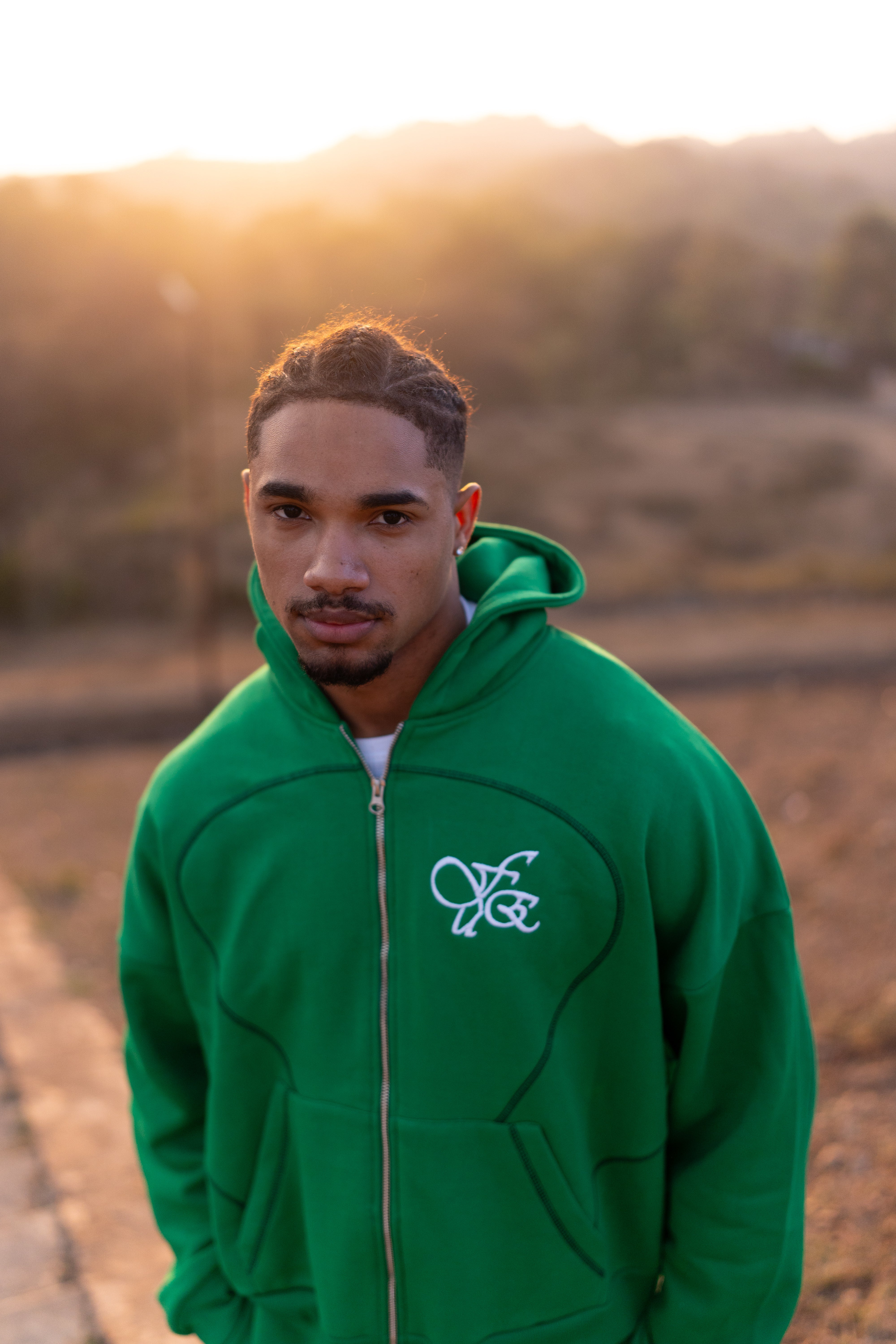 FUE Everyday Essential Sweatshirt Green - male model wearing green hoodie with FUE logo outdoors