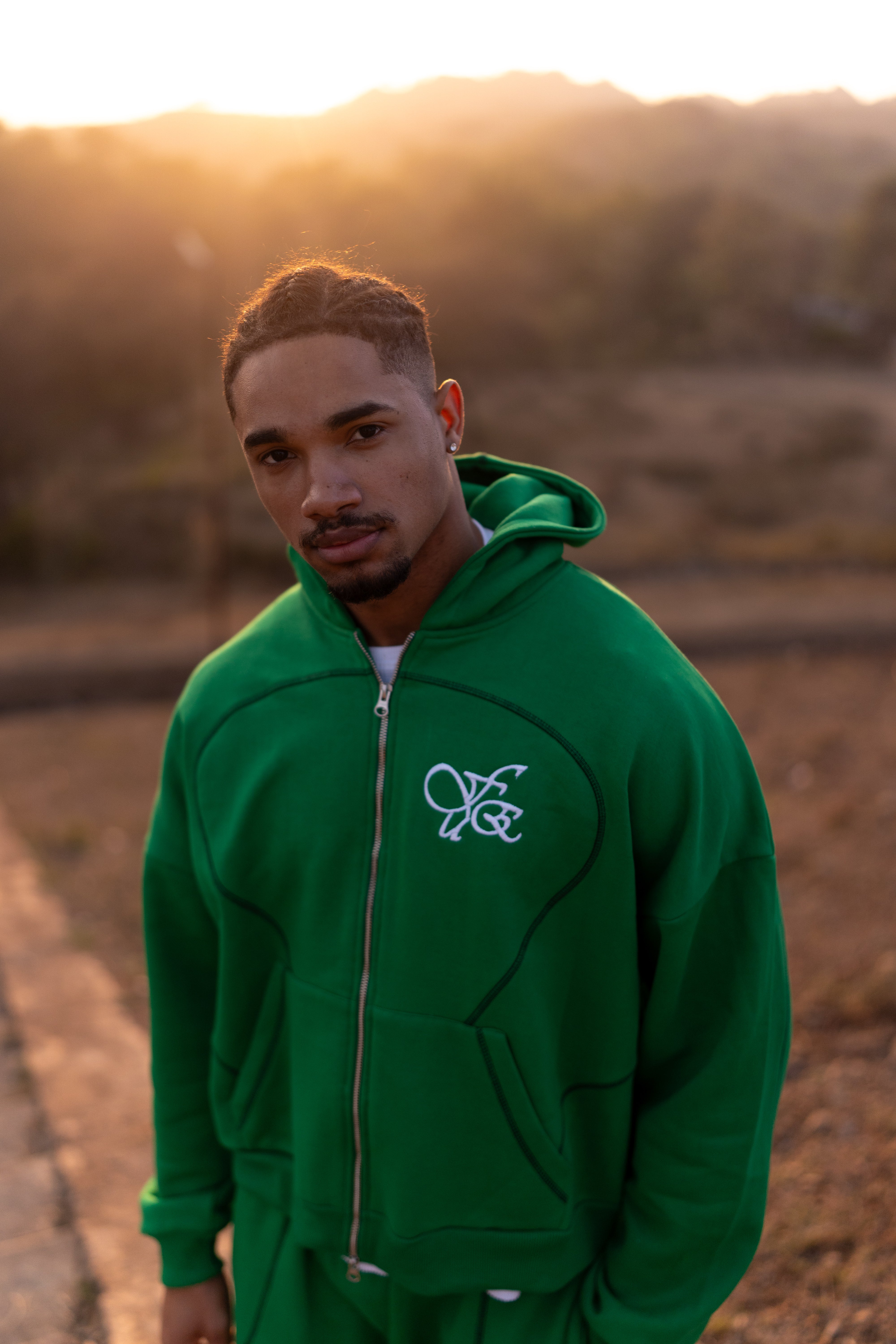 FUE Everyday Essential Sweatshirt Green - male model in green hoodie with FUE logo at sunset