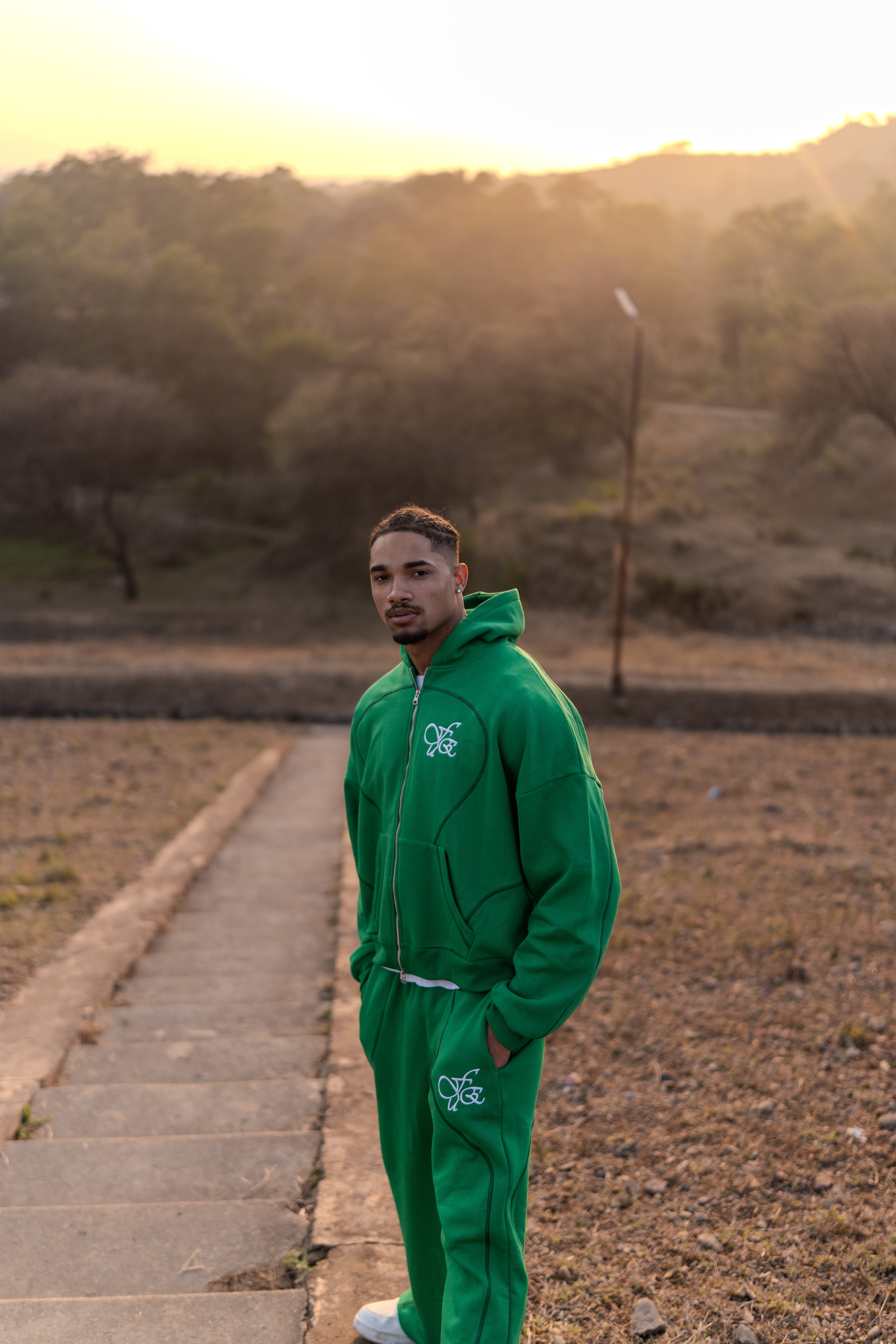 FUE Everyday Essential Sweatpants Green - male model in green tracksuit standing on outdoor path