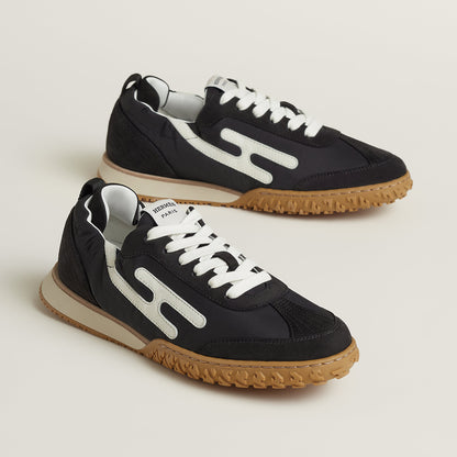 Hermes Jet Sneaker in Noir Blanc, side profile showing the signature H detail